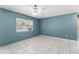 Bright, airy bedroom with tile flooring, a large window, and a modern ceiling fan at 7600 Boreas Dr, Orlando, FL 32822