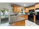 Functional kitchen with wood cabinets, granite countertops, and modern black appliances at 7600 Boreas Dr, Orlando, FL 32822