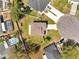 Overhead view of a home showcasing its layout, roof, yard, and proximity to other properties and a community pool at 815 Savona Pl, Kissimmee, FL 34758