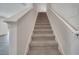 Carpeted staircase with white handrails leads to the upper level, providing a smooth transition between floors at 815 Savona Pl, Kissimmee, FL 34758
