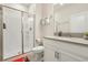 Clean bathroom features a glass-enclosed shower, white vanity with gray countertop, and a rug on the floor at 8959 Stinger Dr, Champions Gate, FL 33896