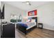 Cozy bedroom features a dark wood bed frame, neutral walls, and hardwood floors for a tranquil retreat at 8959 Stinger Dr, Champions Gate, FL 33896