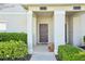 Inviting front porch with covered entrance, complemented by lush greenery and a quaint bench at 8959 Stinger Dr, Champions Gate, FL 33896
