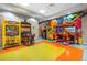 Vibrant game room with various arcade games and colorful flooring at 8959 Stinger Dr, Champions Gate, FL 33896