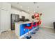 Kitchen features stainless steel appliances, blue bar, white cabinetry, and pendant lighting at 8959 Stinger Dr, Champions Gate, FL 33896