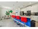 Stylish kitchen features stainless steel appliances, white cabinets, breakfast bar with red barstools, and adjacent dining area at 8959 Stinger Dr, Champions Gate, FL 33896