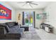 Comfortable living room with backyard pool view, cozy gray sofa, and mounted TV; great for entertaining at 8959 Stinger Dr, Champions Gate, FL 33896