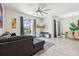 Bright living room with a gray sofa, large windows overlooking the pool, and an adjacent dining area at 8959 Stinger Dr, Champions Gate, FL 33896