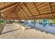 Outdoor picnic area with a thatched roof and picnic tables for casual dining at 8959 Stinger Dr, Champions Gate, FL 33896