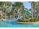 Lazy river with water slide feature winding through tropical landscaping at 8959 Stinger Dr, Champions Gate, FL 33896