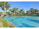 Resort-style pool with palm trees, blue skies, tiki hut and comfortable lounge chairs at 8959 Stinger Dr, Champions Gate, FL 33896