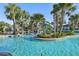Lazy river-style pool winds through lush landscaping with water slide feature at 8959 Stinger Dr, Champions Gate, FL 33896