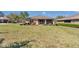 View of the backyard, highlighting the well-manicured lawn, mature trees, and screened-in lanai at 9491 Sw 98Th Ct, Ocala, FL 34481