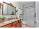 Well-lit bathroom features a vanity with countertop, ornate mirror, shower, and toilet at 9491 Sw 98Th Ct, Ocala, FL 34481
