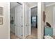 Bright hallway featuring neutral walls, tile flooring, and doorways leading to various rooms at 9491 Sw 98Th Ct, Ocala, FL 34481