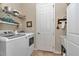 Clean laundry room featuring modern appliances, shelving, and a utility sink at 9491 Sw 98Th Ct, Ocala, FL 34481