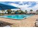Community pool surrounded by lounge chairs and palm trees for a resort-like atmosphere at 9491 Sw 98Th Ct, Ocala, FL 34481