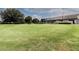 Putting green with meticulously maintained grass, set against the backdrop of a modern clubhouse at 9491 Sw 98Th Ct, Ocala, FL 34481
