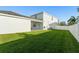 Green backyard with a white fence, a patio, and well-maintained lawn at 9844 Pecan Hickory Way, Orlando, FL 32832