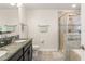 Bright bathroom with a tiled shower and a granite-topped vanity with double sinks at 9844 Pecan Hickory Way, Orlando, FL 32832