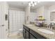 Bathroom featuring double sinks, granite countertops, a tiled floor and bath with shower at 9844 Pecan Hickory Way, Orlando, FL 32832