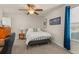 Bright bedroom features a ceiling fan, side table, and picture window at 9844 Pecan Hickory Way, Orlando, FL 32832