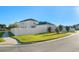 Corner lot featuring a spacious lawn, white vinyl fence, and a paved driveway to the garage at 9844 Pecan Hickory Way, Orlando, FL 32832