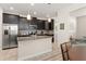 Stylish kitchen showcasing dark cabinets, stainless steel appliances, granite countertops, and an island with pendant lighting at 9844 Pecan Hickory Way, Orlando, FL 32832
