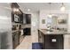 Modern kitchen featuring stainless steel appliances, dark cabinetry, granite countertops, and an island with bar seating at 9844 Pecan Hickory Way, Orlando, FL 32832