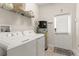 A clean laundry room has modern appliances, shelving, and a door at 9844 Pecan Hickory Way, Orlando, FL 32832