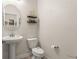 Modern powder room with a pedestal sink, decorative shelves, and neutral decor at 9844 Pecan Hickory Way, Orlando, FL 32832