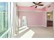 Bedroom featuring a pink accent wall, carpet, city views, and an adjoining bathroom at 101 S Eola Dr # 910, Orlando, FL 32801