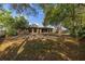 Expansive backyard with mature trees, a fire pit, and a serene view of the home at 1061 Radford Dr, Deltona, FL 32738