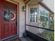 Charming front entrance featuring a vibrant red door, brick facade, and welcoming wreath for added curb appeal at 1061 Radford Dr, Deltona, FL 32738