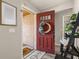 Inviting entryway with a red front door, adorned with a wreath, leading into a bright and stylish home at 1061 Radford Dr, Deltona, FL 32738