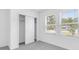 Well-lit bedroom with carpeting, featuring a closet and bright windows for a comfortable living space at 144 Jones Fish Camp Rd, Edgewater, FL 32141