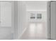 Hallway features sleek tile flooring leading to a naturally lit living area with bright windows at 144 Jones Fish Camp Rd, Edgewater, FL 32141