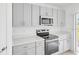 Kitchen close up featuring stainless steel oven, stove, microwave and gray cabinets at 144 Jones Fish Camp Rd, Edgewater, FL 32141