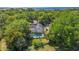 Aerial view of a home with a screened-in pool in a lush, wooded setting near the water at 1511 Grandview Blvd, Kissimmee, FL 34744