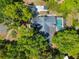 Aerial view of a charming home with a screened-in pool surrounded by mature trees at 1511 Grandview Blvd, Kissimmee, FL 34744