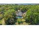 Aerial view of a home with a screened-in pool in a lush, wooded setting near the water at 1511 Grandview Blvd, Kissimmee, FL 34744