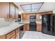 This kitchen features wooden cabinets, a skylight, black appliances, and plenty of counter space at 1511 Grandview Blvd, Kissimmee, FL 34744