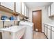 This laundry room features white appliances, overhead cabinets, laminate countertops, and hardwood floors at 1511 Grandview Blvd, Kissimmee, FL 34744