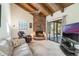 Inviting living room with a stone fireplace, wood beam ceiling, and sliding glass doors to the patio at 1511 Grandview Blvd, Kissimmee, FL 34744