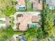 Aerial view of a stunning home with a terracotta tile roof, private pool, meticulously manicured lawns, and a curved driveway at 1630 Lasbury Ave, Winter Park, FL 32789