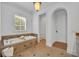 Well-lit bathroom with a soaking tub, travertine tile, and a separate toilet room at 1630 Lasbury Ave, Winter Park, FL 32789