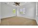 Spacious bedroom featuring a ceiling fan, neutral carpet, and multiple windows for natural light at 1630 Lasbury Ave, Winter Park, FL 32789