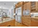 Spacious kitchen featuring stainless steel refrigerator and wooden cabinets with granite countertops at 1630 Lasbury Ave, Winter Park, FL 32789