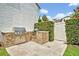 Outdoor kitchen features built-in stainless steel grill on patio with stone detailing and a white fence at 1630 Lasbury Ave, Winter Park, FL 32789