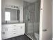 Bathroom featuring double vanity sinks, a glass-enclosed shower, and contemporary finishes at 1647 Redfin Dr, Kissimmee, FL 34759